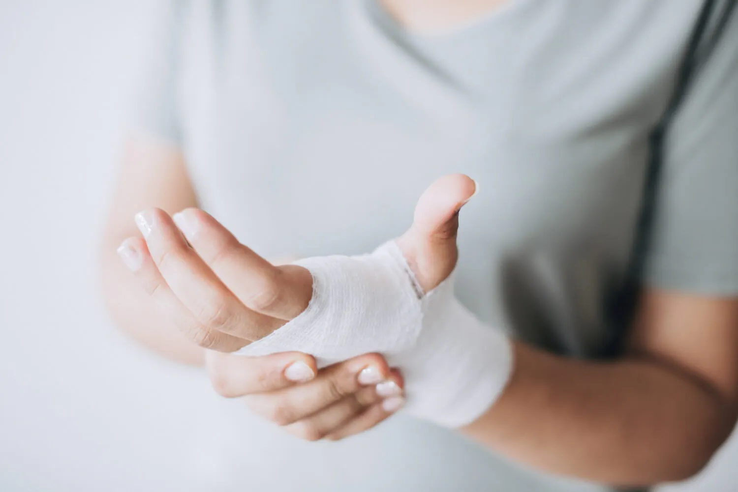 Frau fasst sich an ihre verbundene Hand