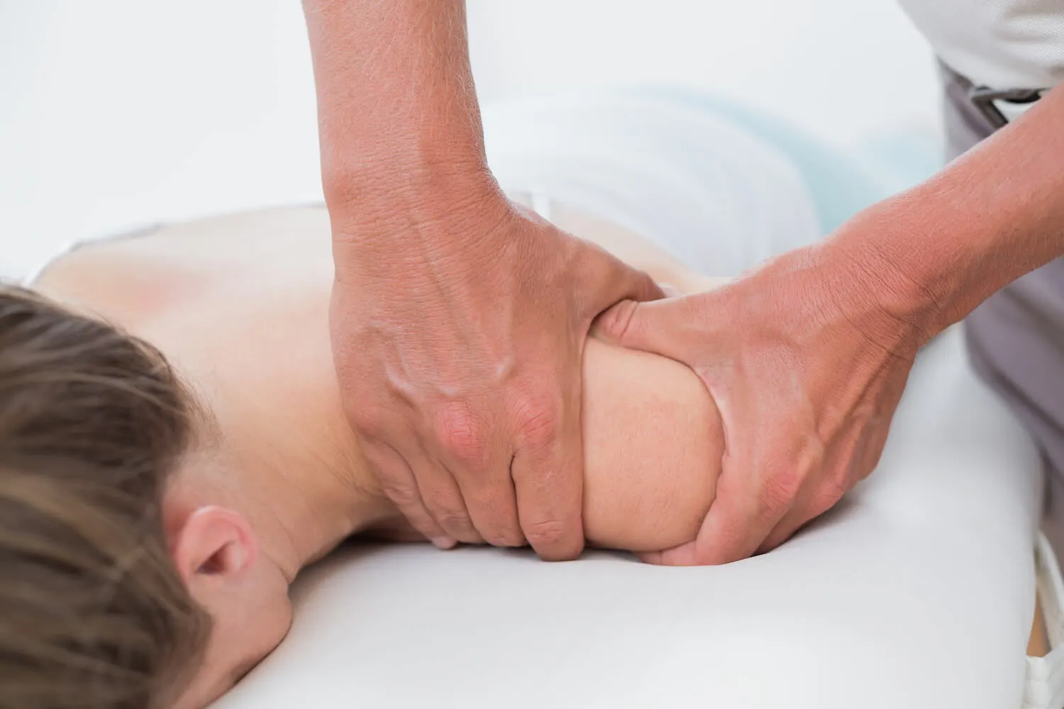 Physiotherapeut behandelt die Schulter einer Patientin