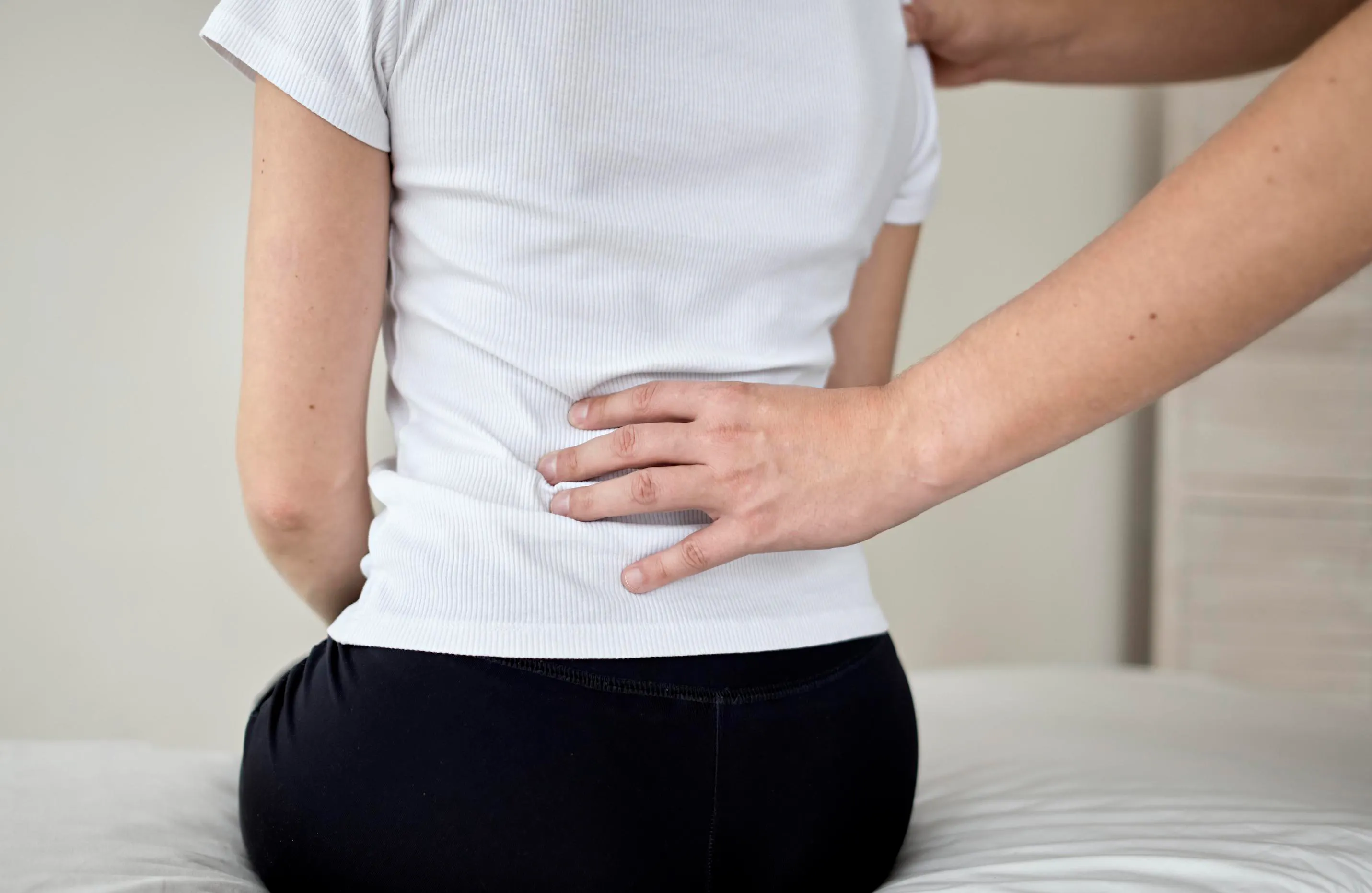 Arzt untersucht den Rücken einer Patientin