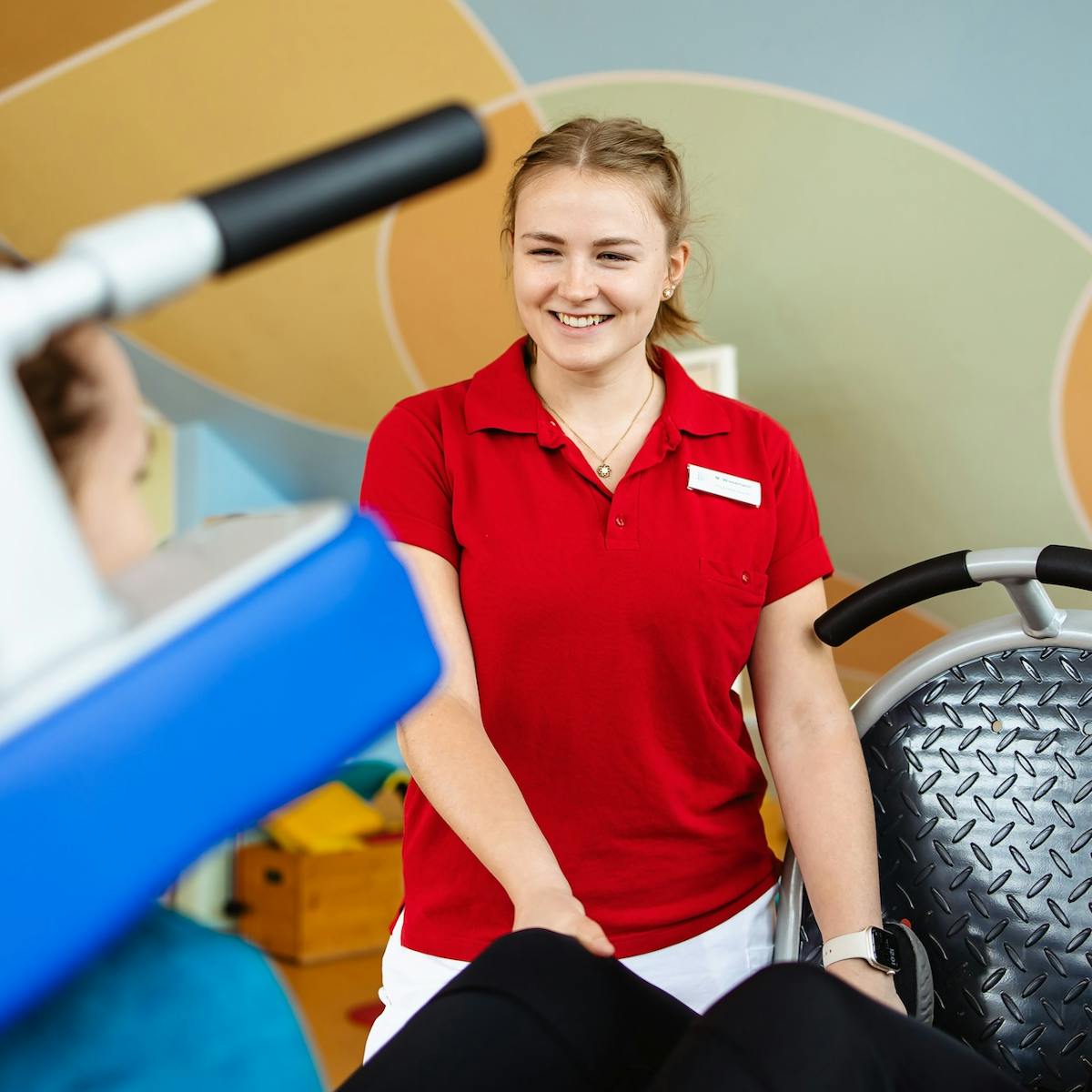 Physiotherapeutin hilft Patientin mit Knieprothese bei einer Übung