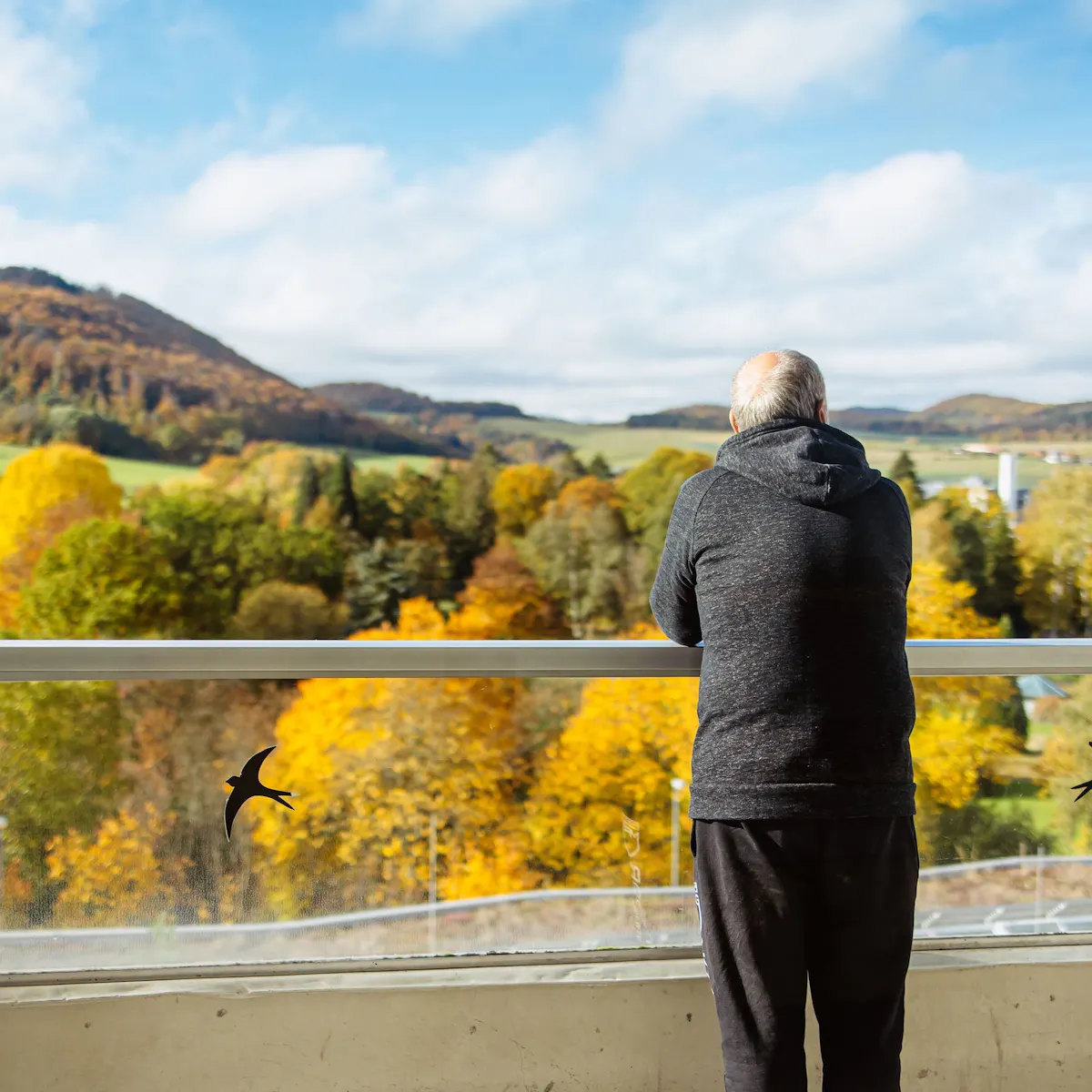MS Patient steht auf dem Balkon und schaut in die grüne Umgebung von Bad Wildungen