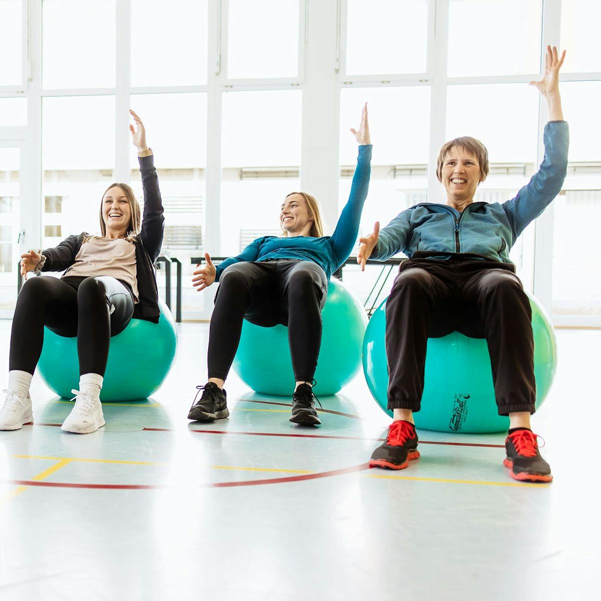 Patientinnen auf Gymnastikbällen bei der Bewegungstherapie