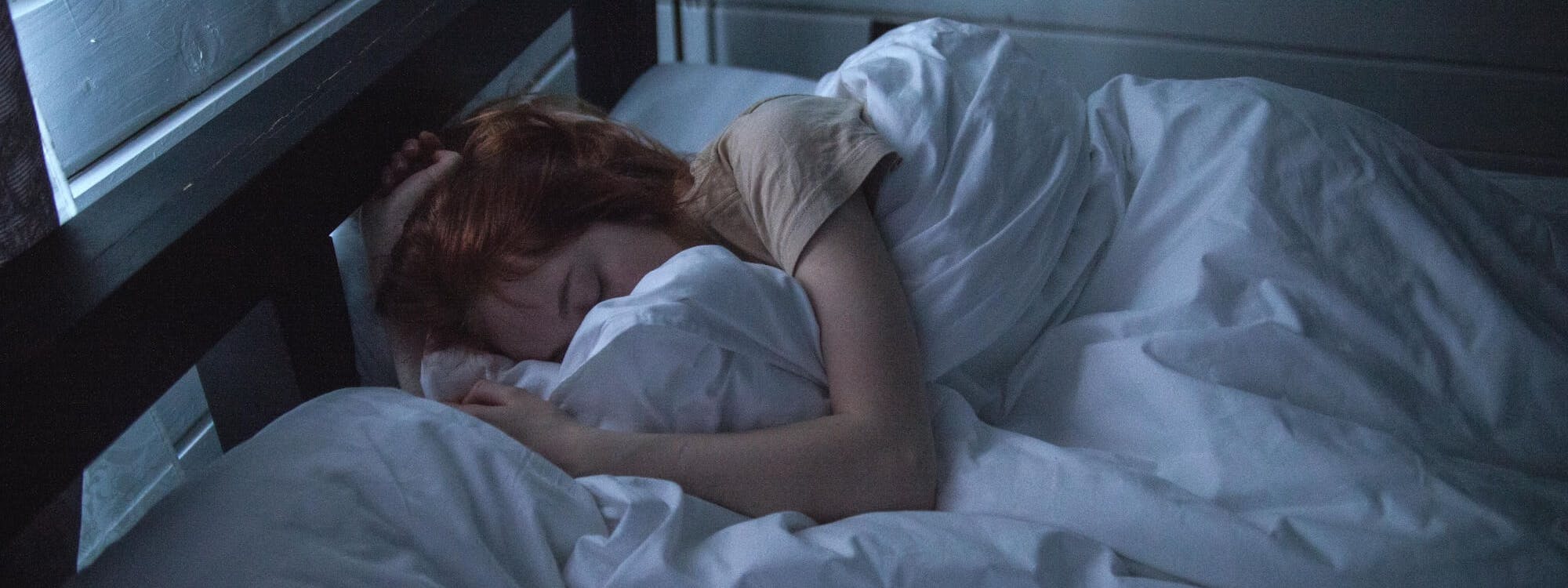 Erschöpfte Frau liegt im Bett und schläft Erschöpfte Frau liegt im Bett und schläft