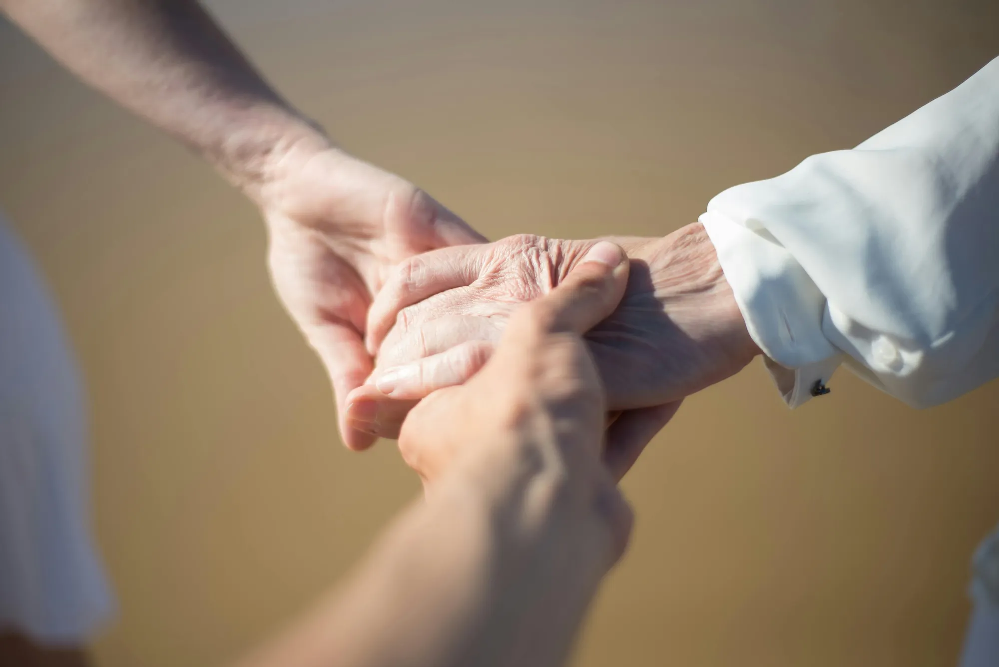 Drei Generationen halten ihre Hände zusammen