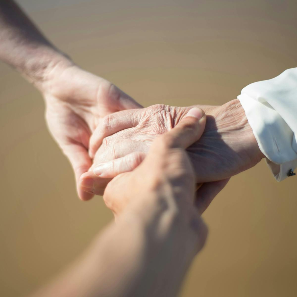 Drei Hände halten sich fest