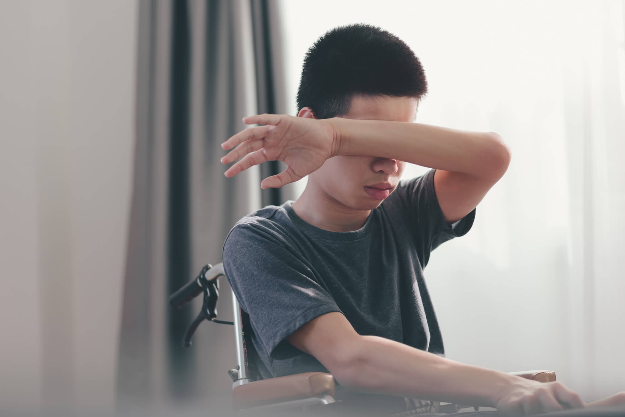 Junge mit Multipler Sklerose im Rollstuhl