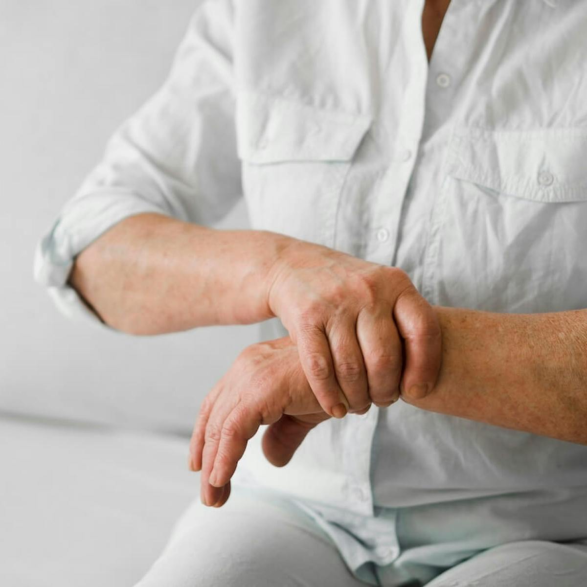 Mann mit Rheuma hält sein Handgelenk fest