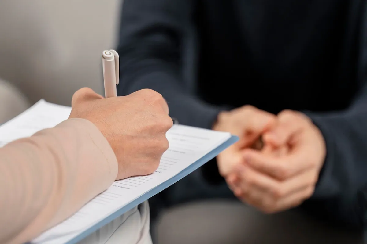 Psychologe schreibt etwas auf ein Klemmbrett