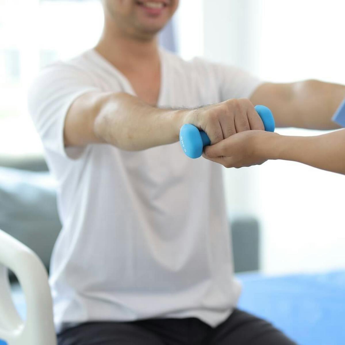 Schlaganfall Patient bei der Physiotherapie hält ein Gewicht nach vorne