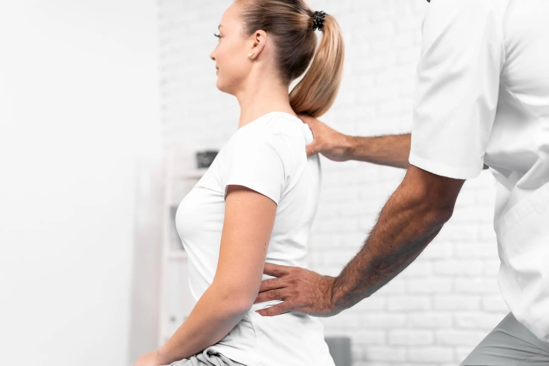 Therapeut fasst Patientin an den Rücken