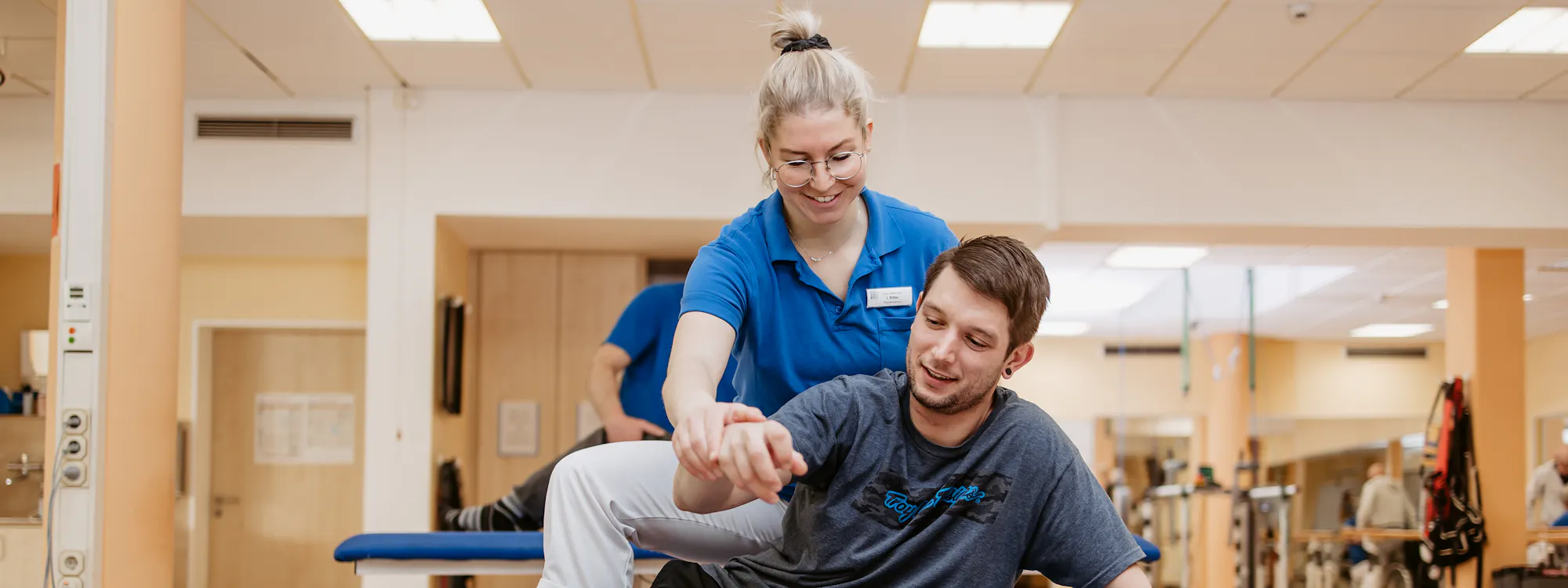 Physiotherapeutische Behandlung querschnittgelähmter Patient auf Liege mit Physiotherapeutin Physiotherapeutische Behandlung querschnittgelähmter Patient auf Liege mit Physiotherapeutin