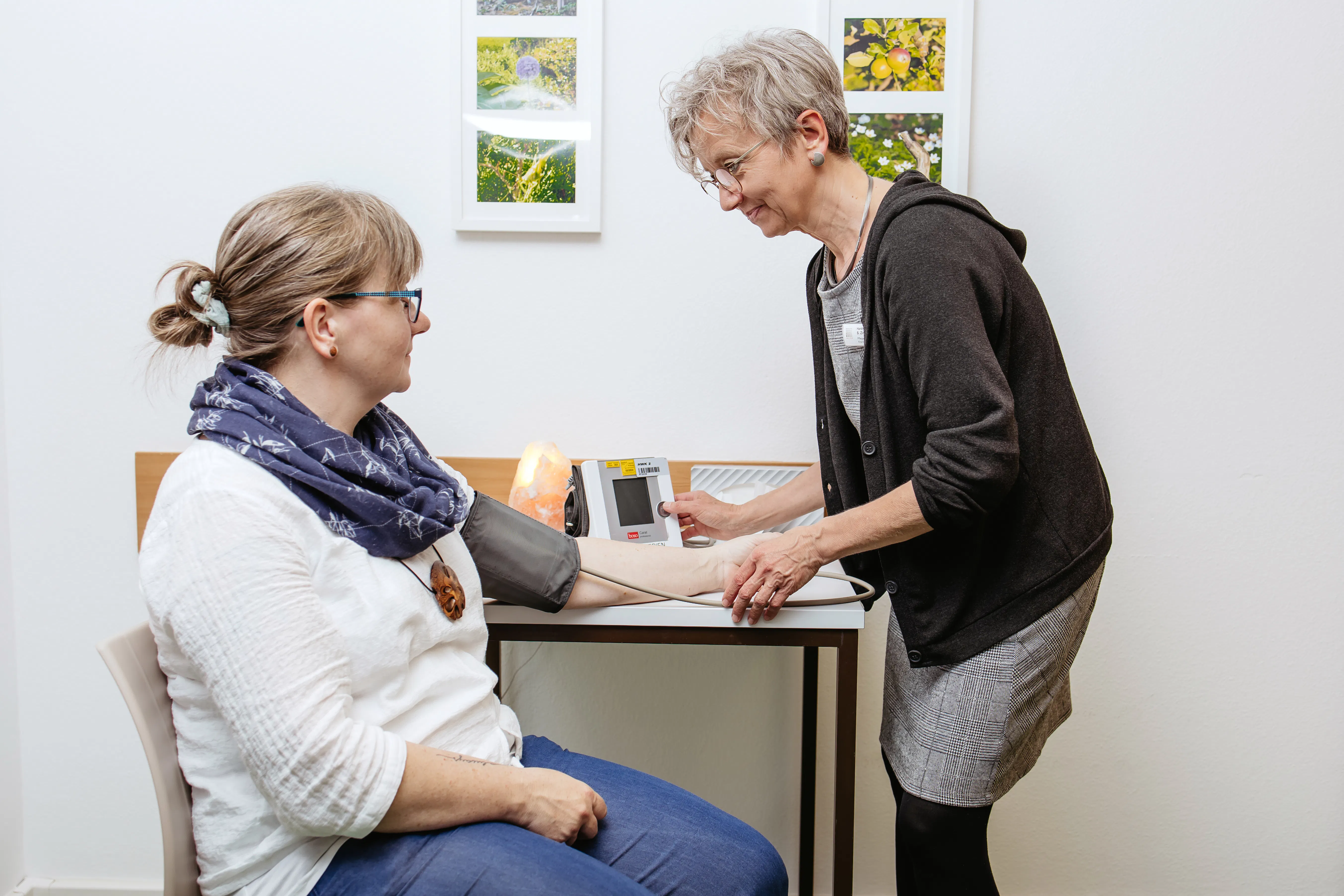 Medizinische Fachangestellte misst den Blutdruck bei einer weiblichen Patientin