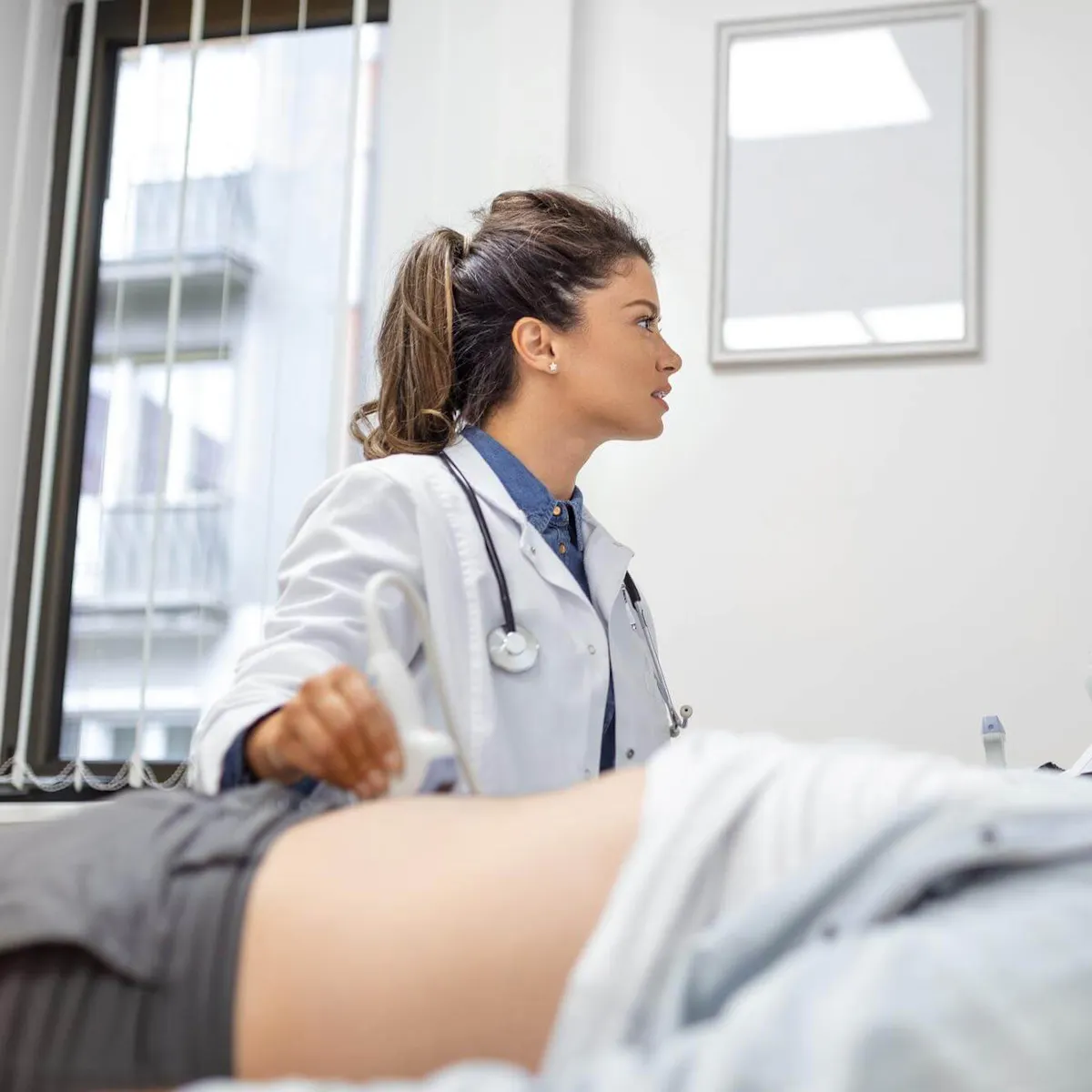 Ärztin untersuch per Ultraschall die Nieren eines Patienten