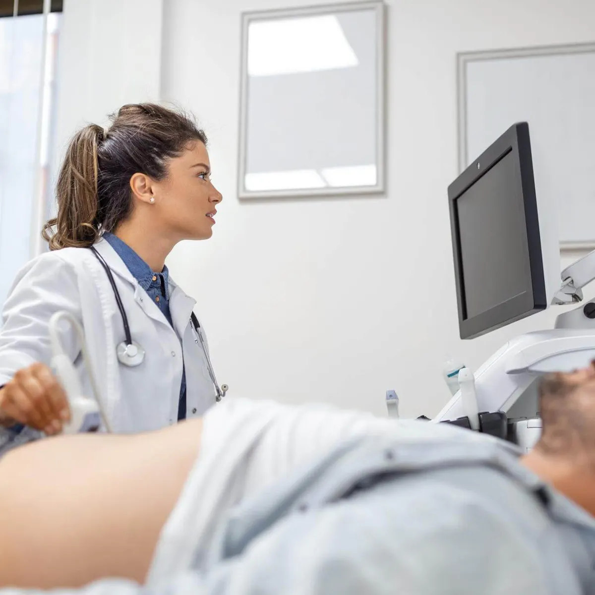 Ärztin untersucht Harnblase eines Patienten