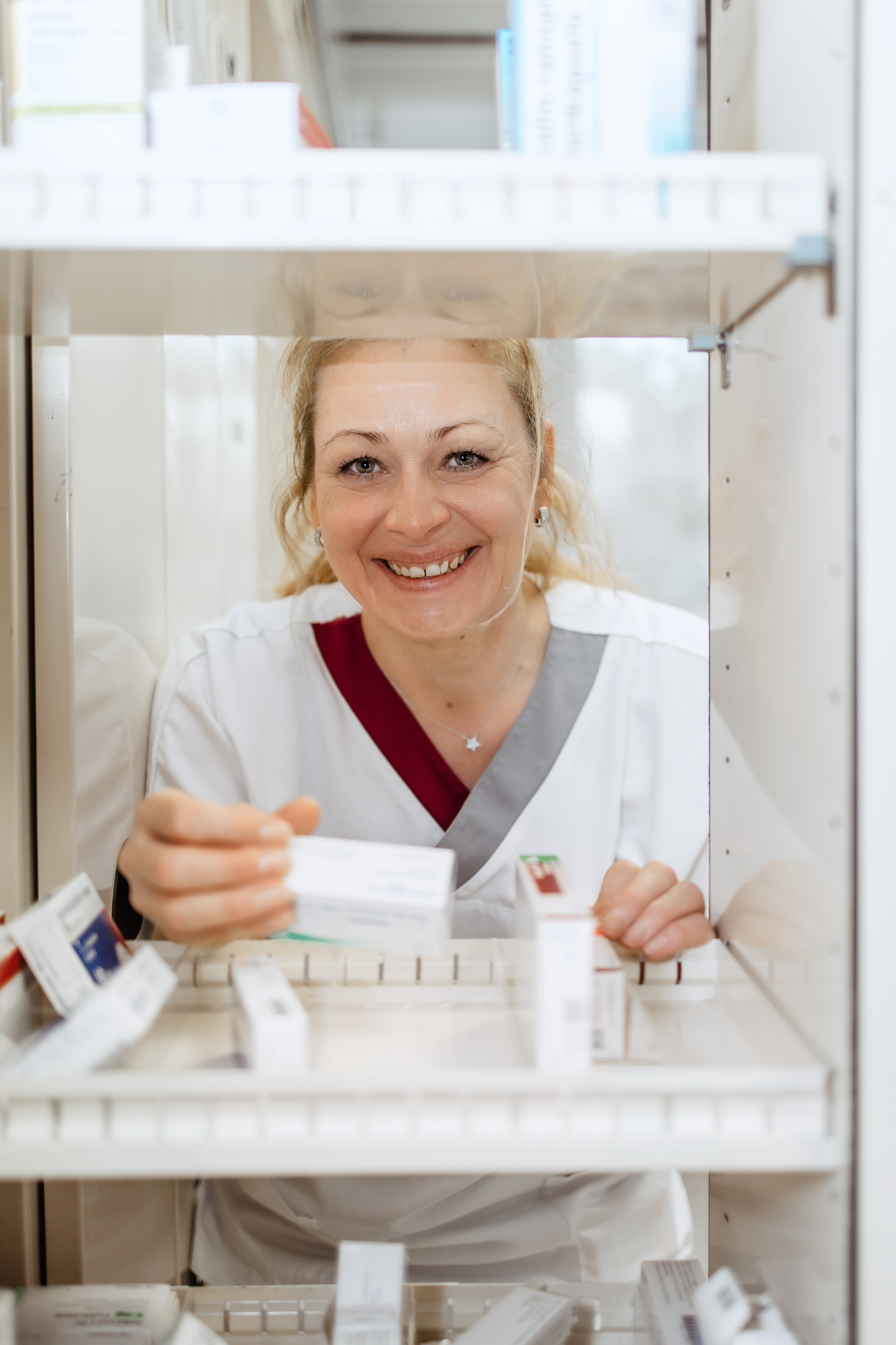 Mitarbeiterin der neurologischen Abteilung nimmt Medikamente aus einem Schrank