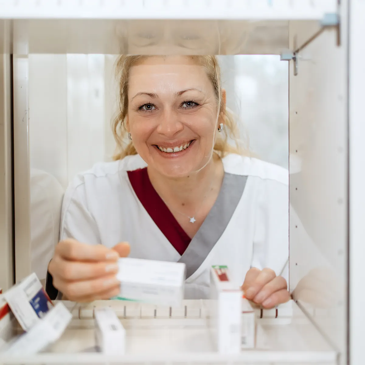 Mitarbeiterin der neurologischen Abteilung nimmt Medikamente aus einem Schrank