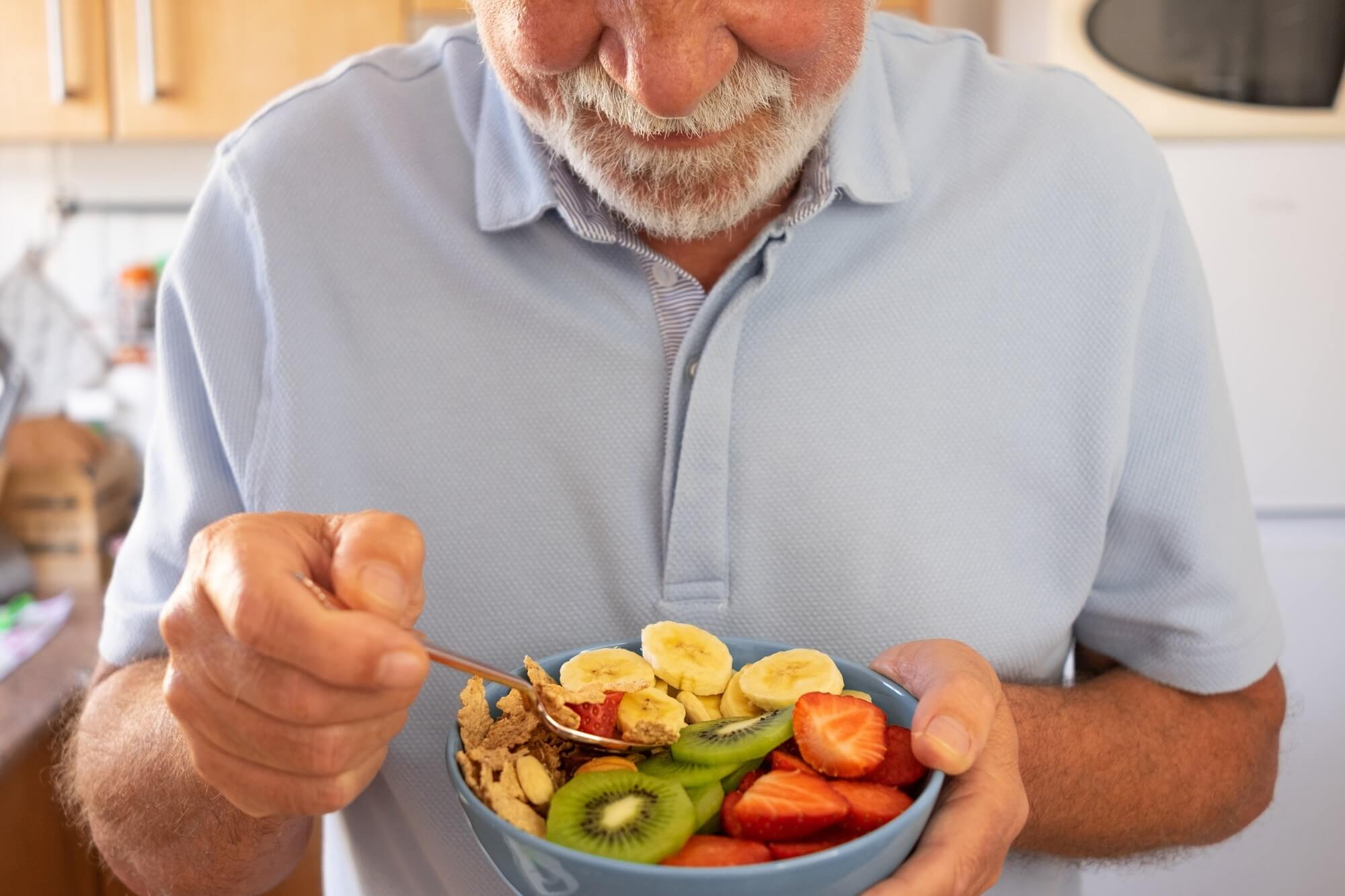 Mann mit Fibromyalgie isst Müsli mit Obst