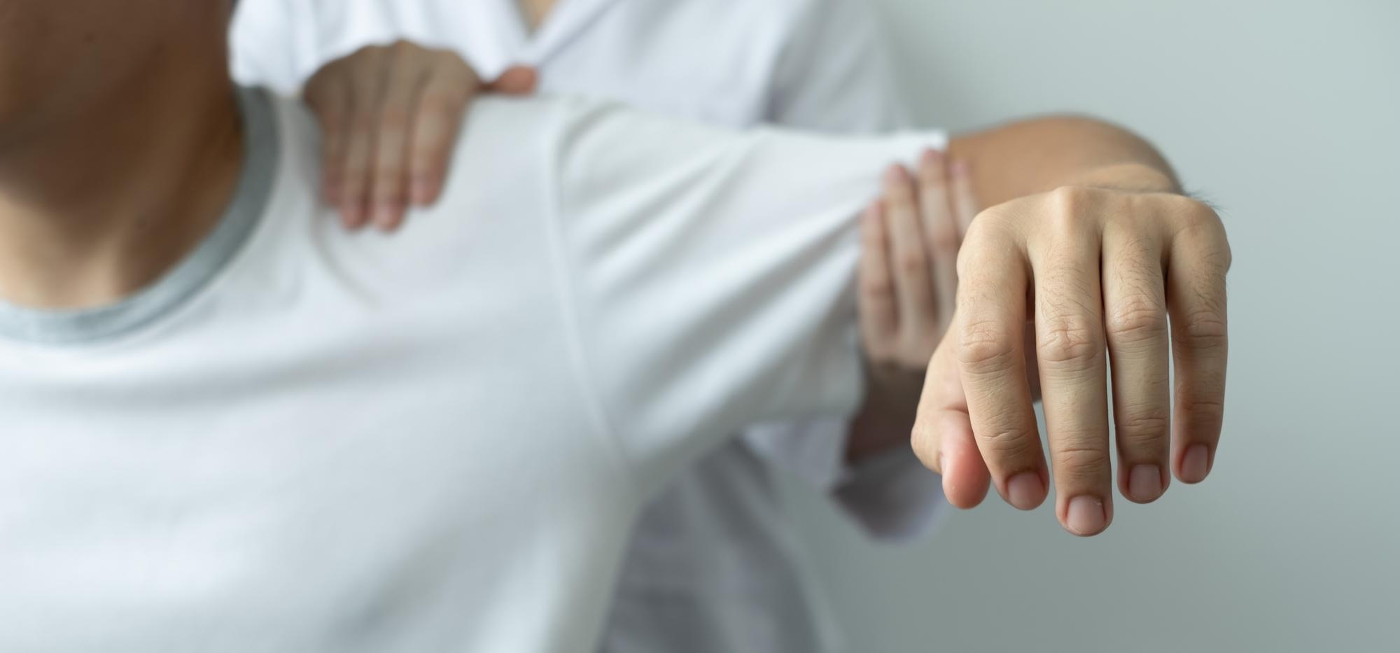 Patient mit CRPS hebt seinen Arm bei einer Beweglichkeitsübung