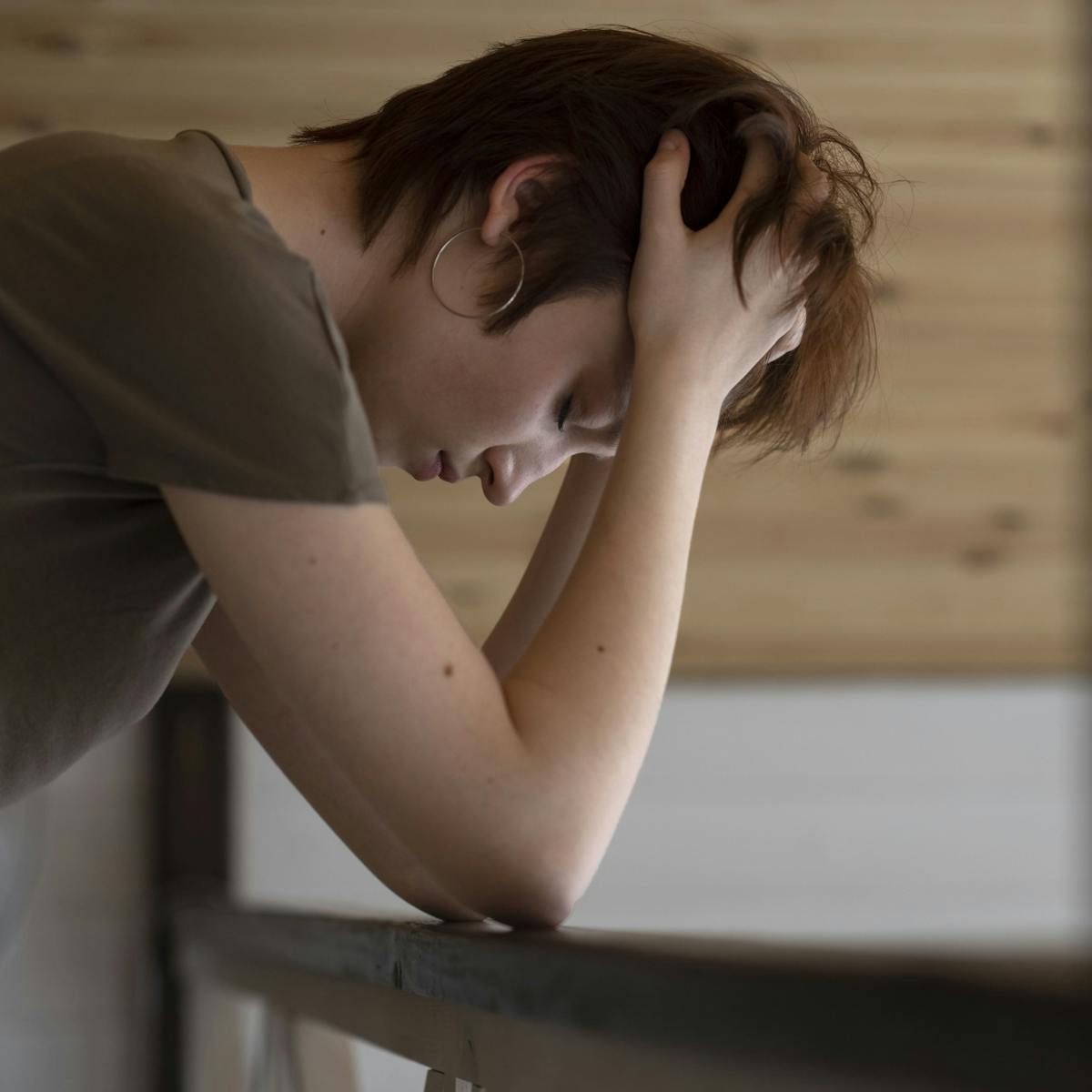 Besorgte Frau stützt mit ihren Armen ihren Kopf auf dem Tisch