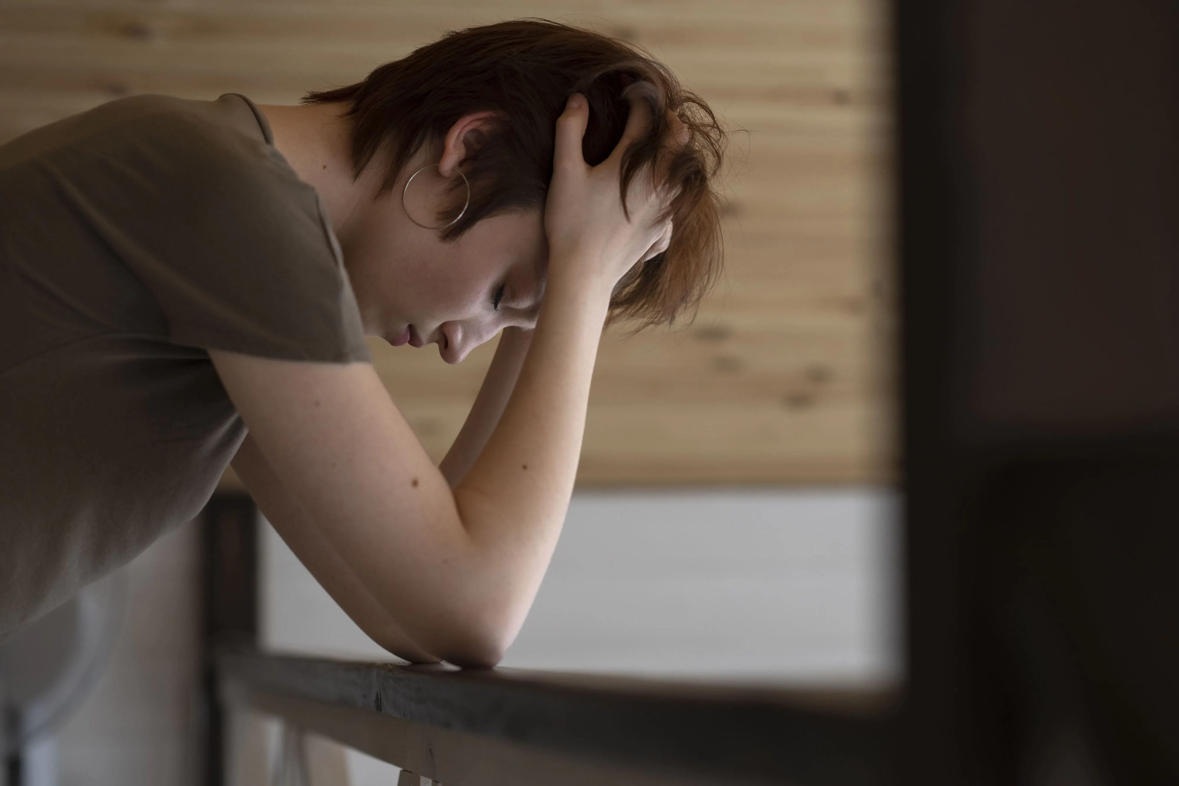 Person stützt ihren Kopf auf einen Tisch