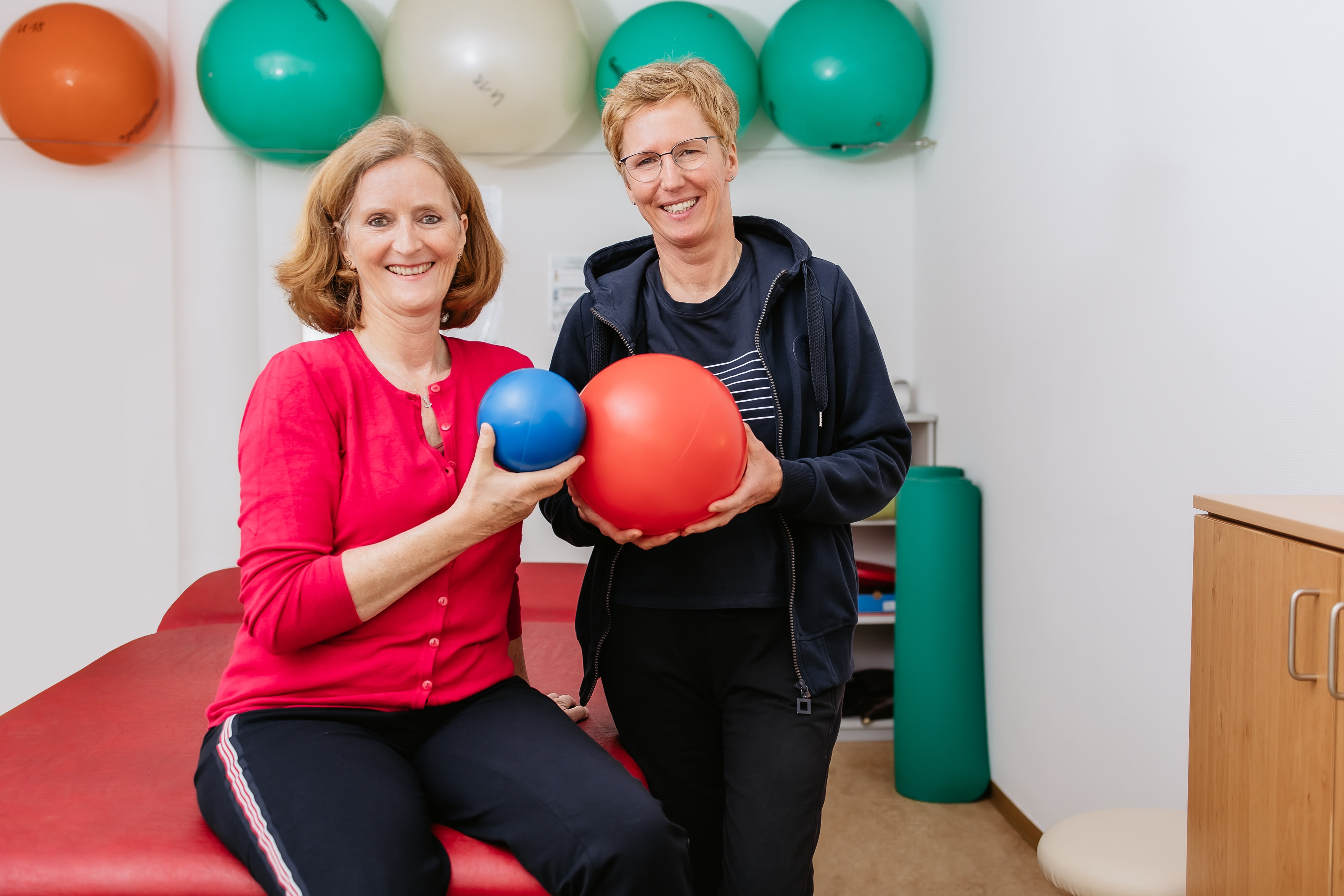 Patientin und Therapeutin mit Bällen in der Hand bei der Physiotherapie