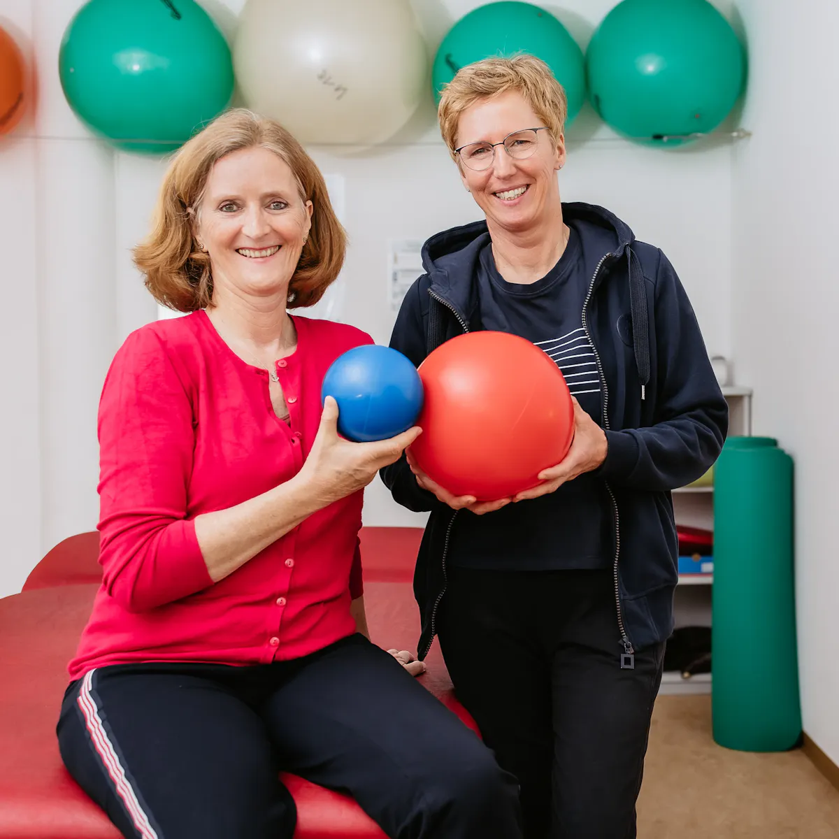 Patientin und Therapeutin mit Bällen in der Hand bei der Physiotherapie