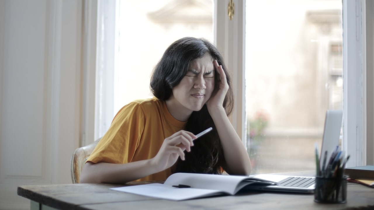 Frau mit Cluster Kopfschmerzen fasst sich an den Kopf