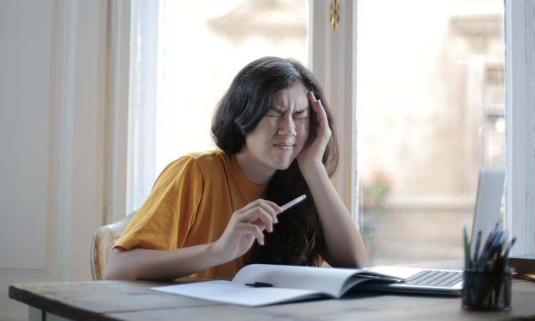 Frau mit Cluster Kopfschmerzen fasst sich an den Kopf