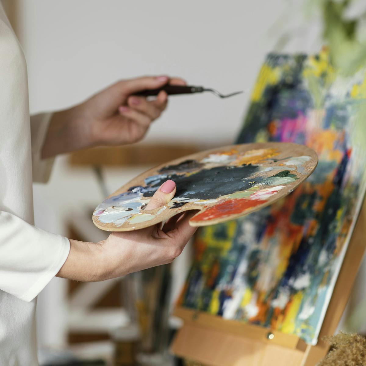 Person hält eine Farbpalette während der Kunsttherapie