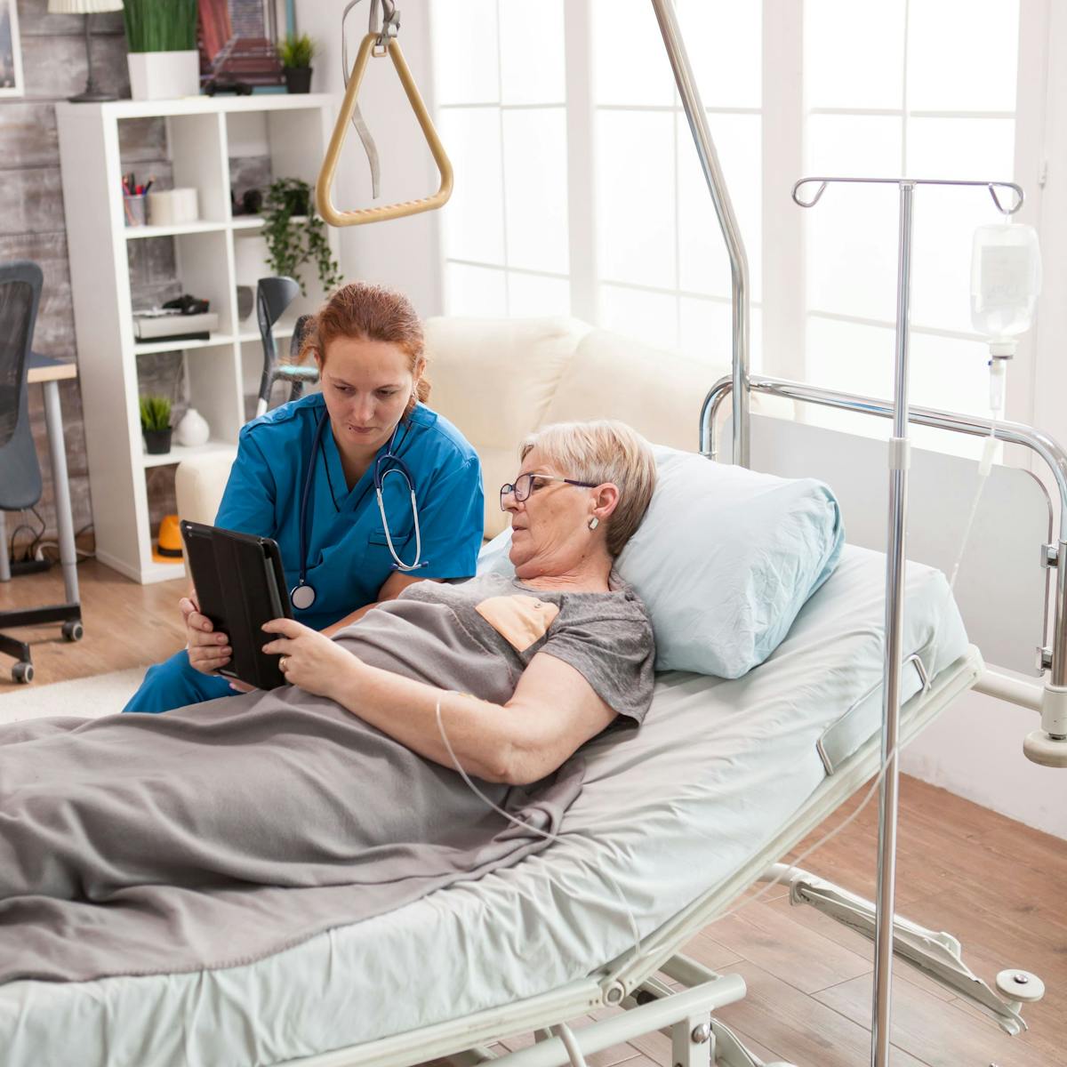 MFS Patientin im Krankenhausbett spricht mit Pflegepersonal