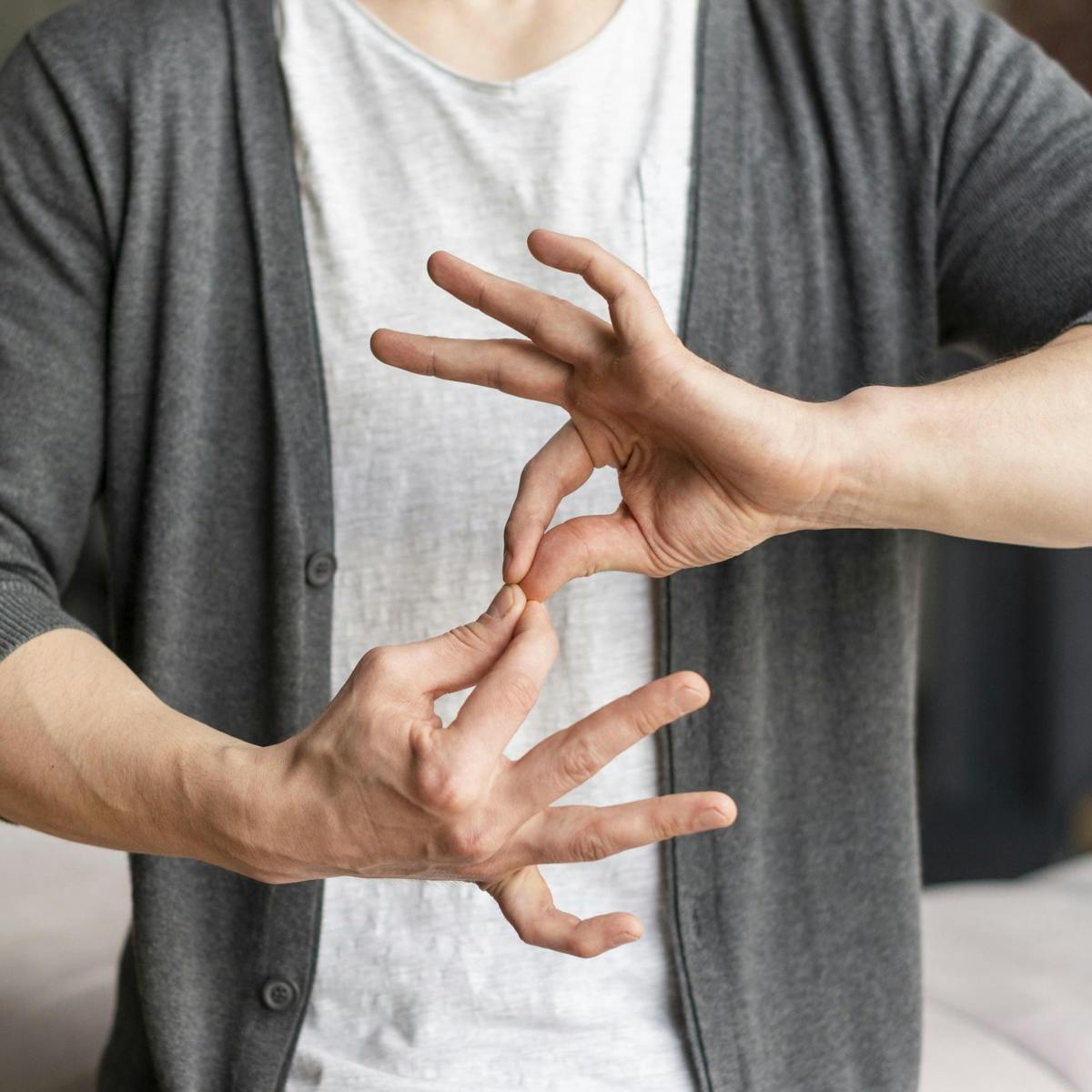 Person fasst sich mit beiden Händen an die Fingerspitzen