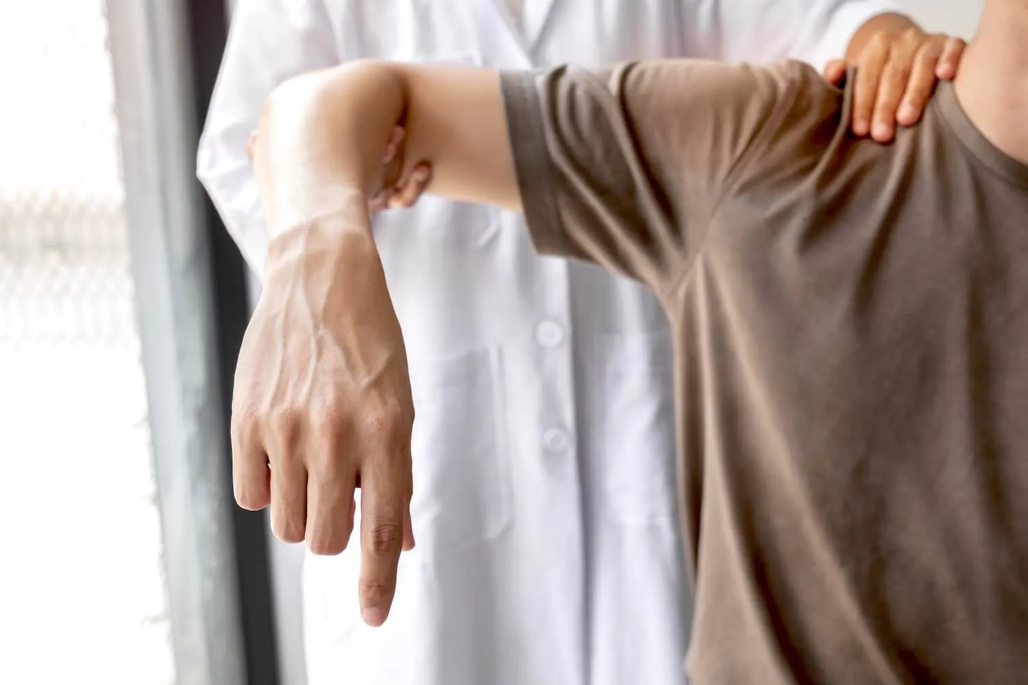 Arzt untersucht die Schulter eines Patienten