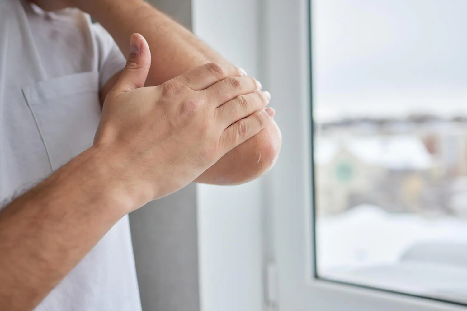 Mann tastet seinen Arm ab