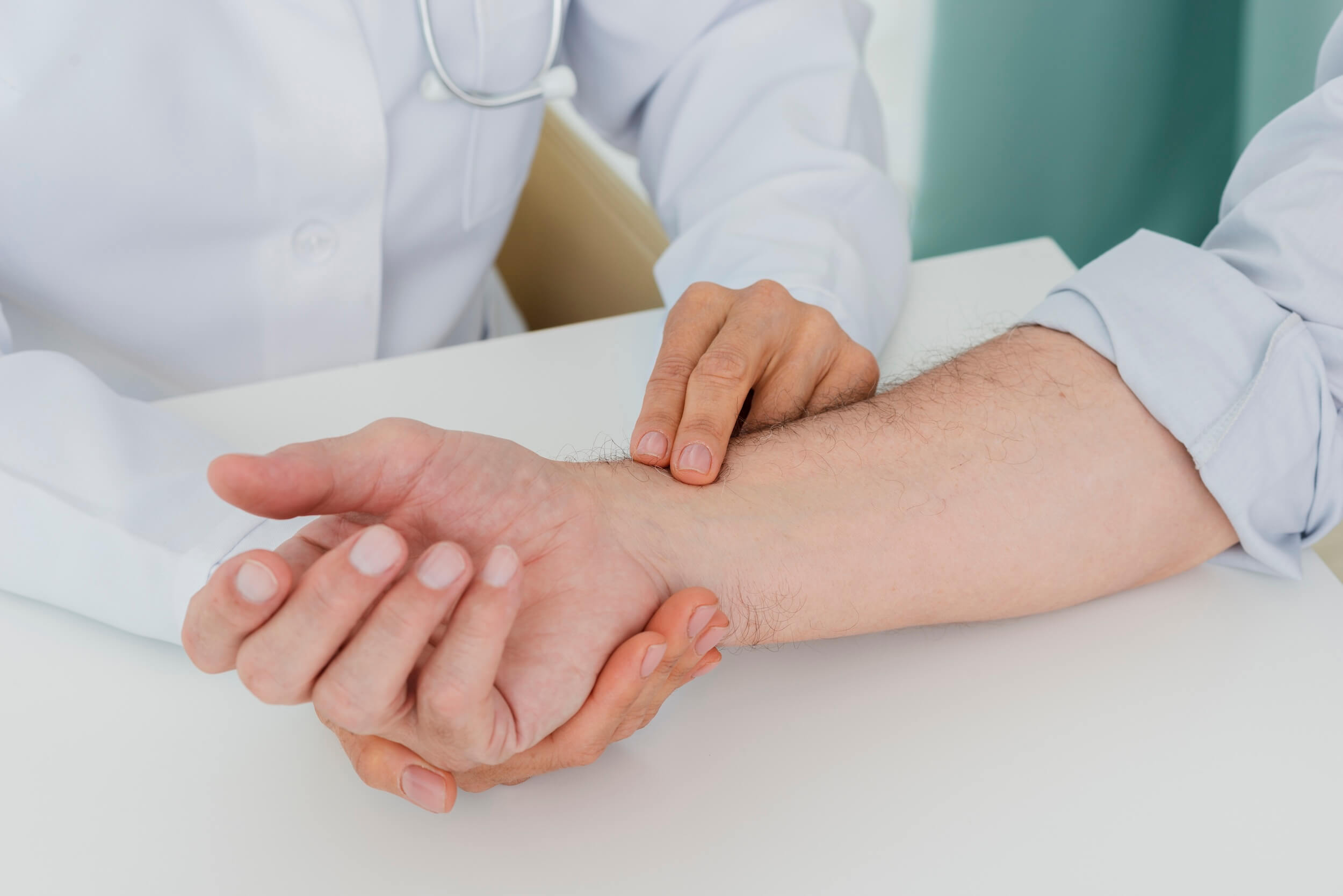 Arzt tastet den Unterarm eines Patienten auf Sarkome ab
