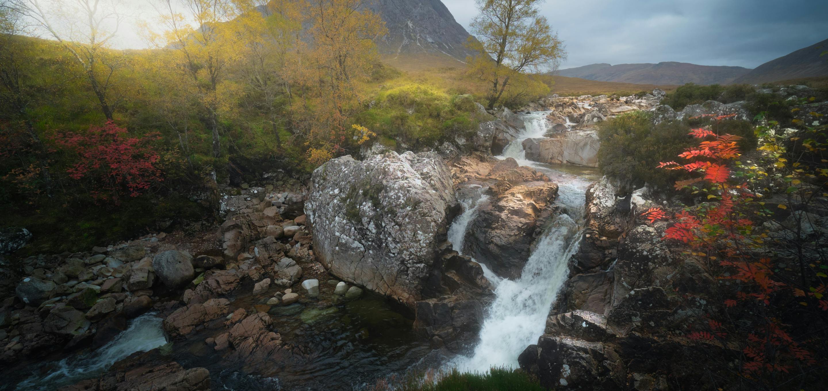 natural stream in front of mountain in the day time