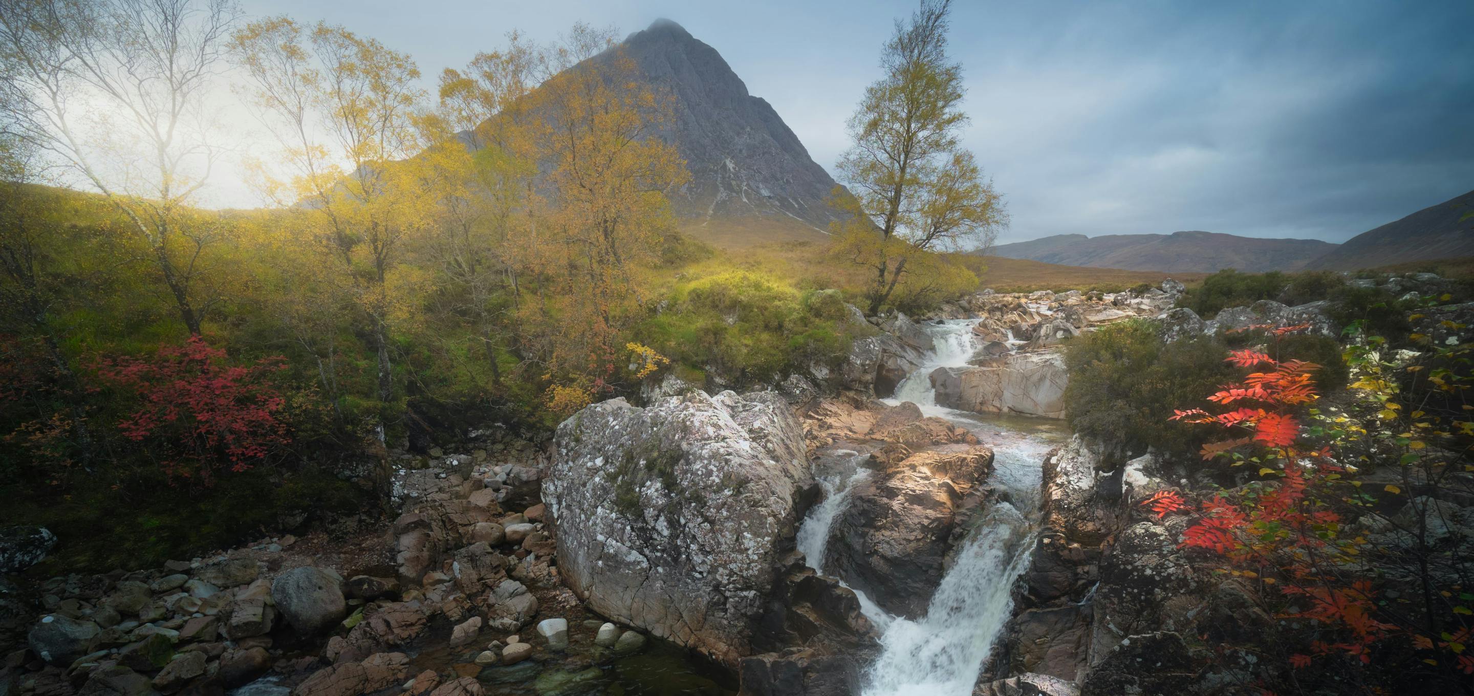 natural stream in front of mountain in the day time