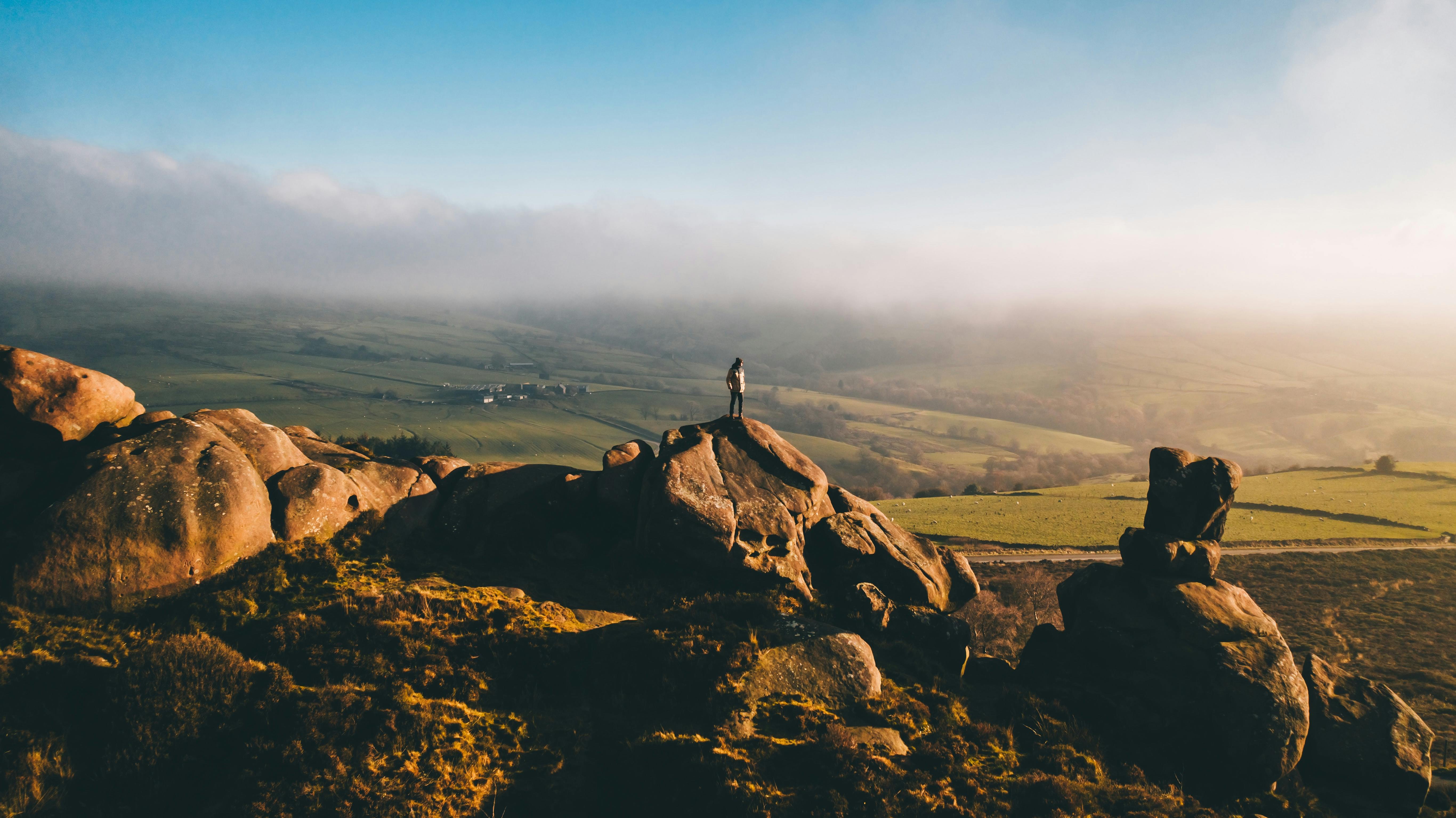 hills with person on top of a rock