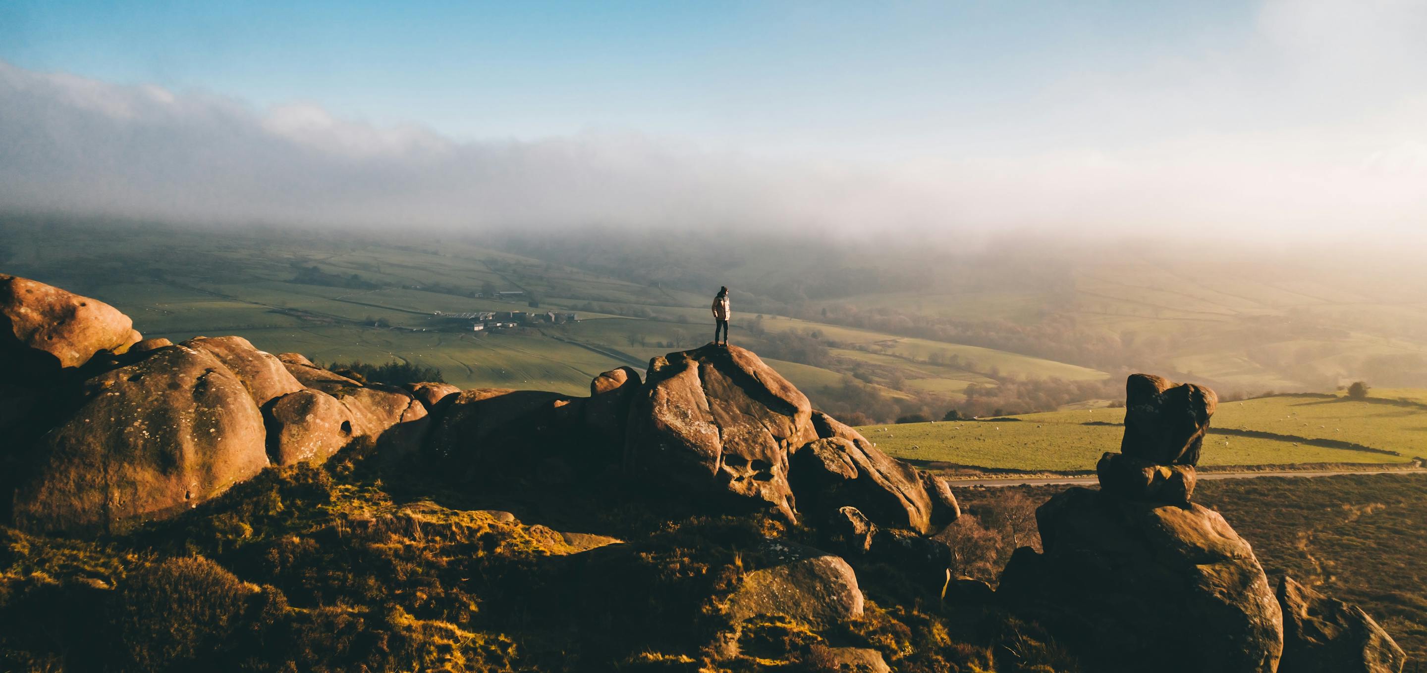 hills with person on top of a rock