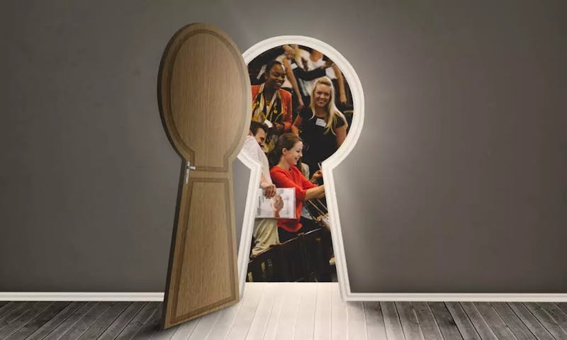 A group of women in a meeting are inside a keyhole