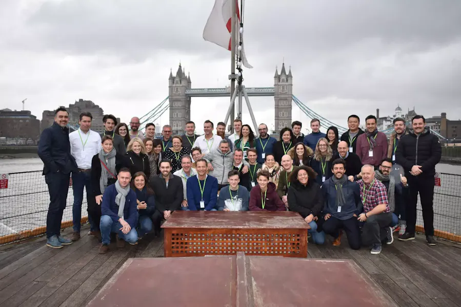 Group of people posing in front of Tower Bridge, London UK