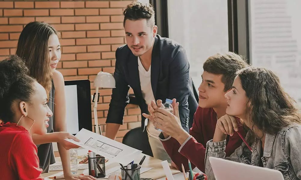 Group of people in an office discussing notes