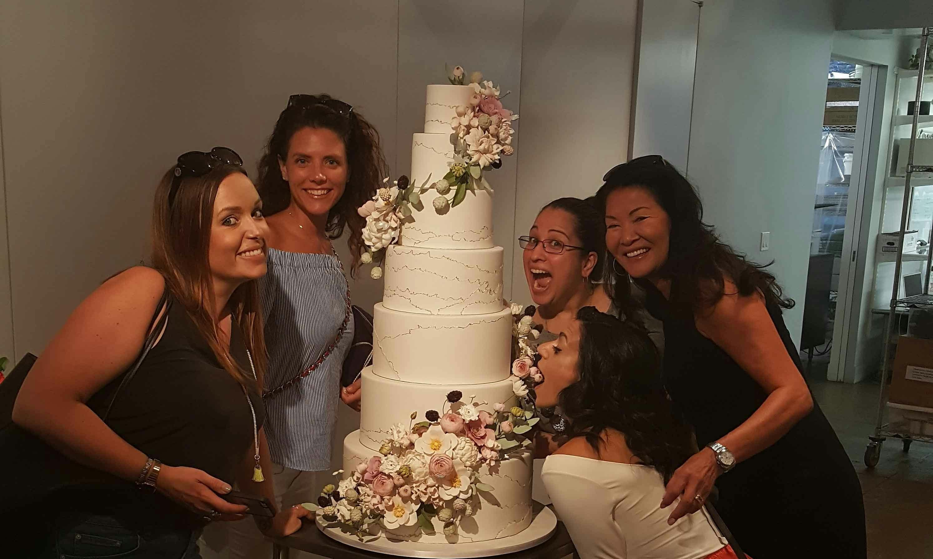 Women gathered around a decorated wedding cake