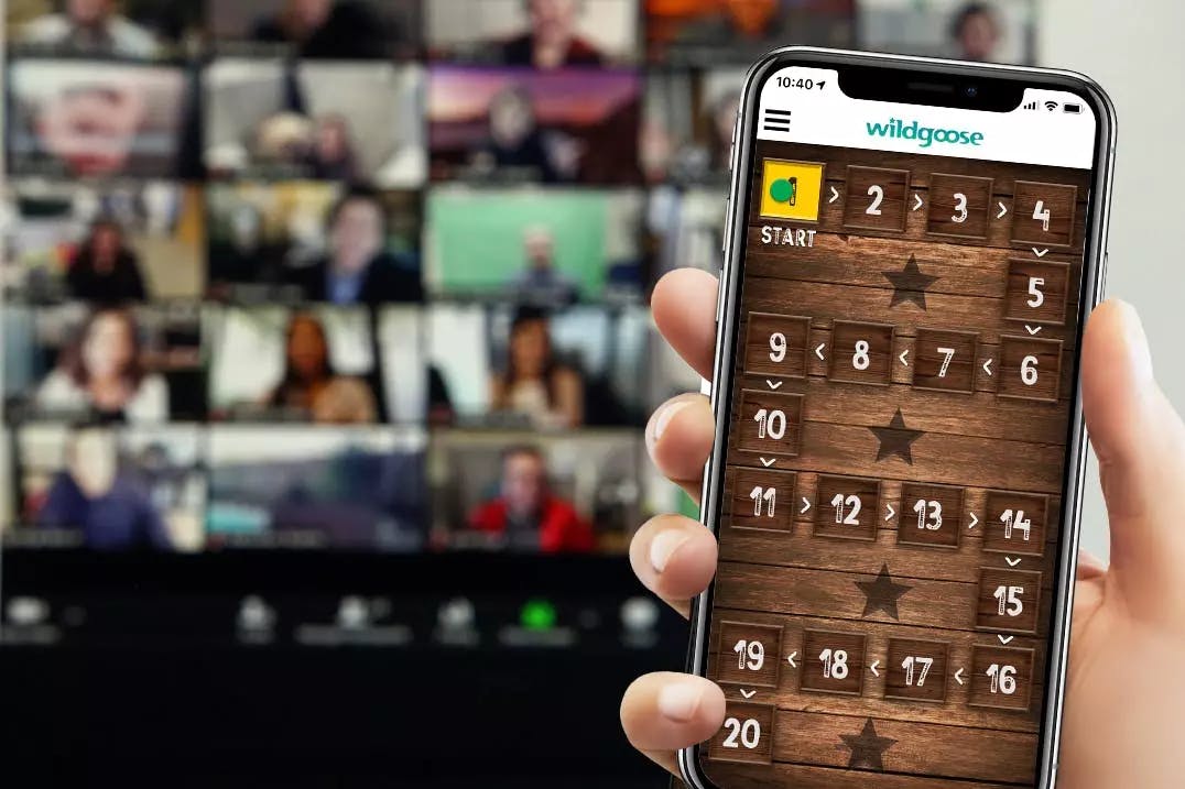 Close up of a hand using a mobile phone, video calls in the background