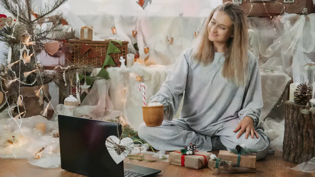 remote worker sitting down in a festively decorated room to play some remote christmas games
