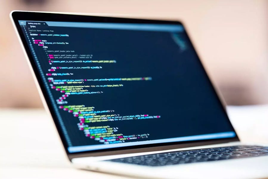 A laptop with web or application development on desk