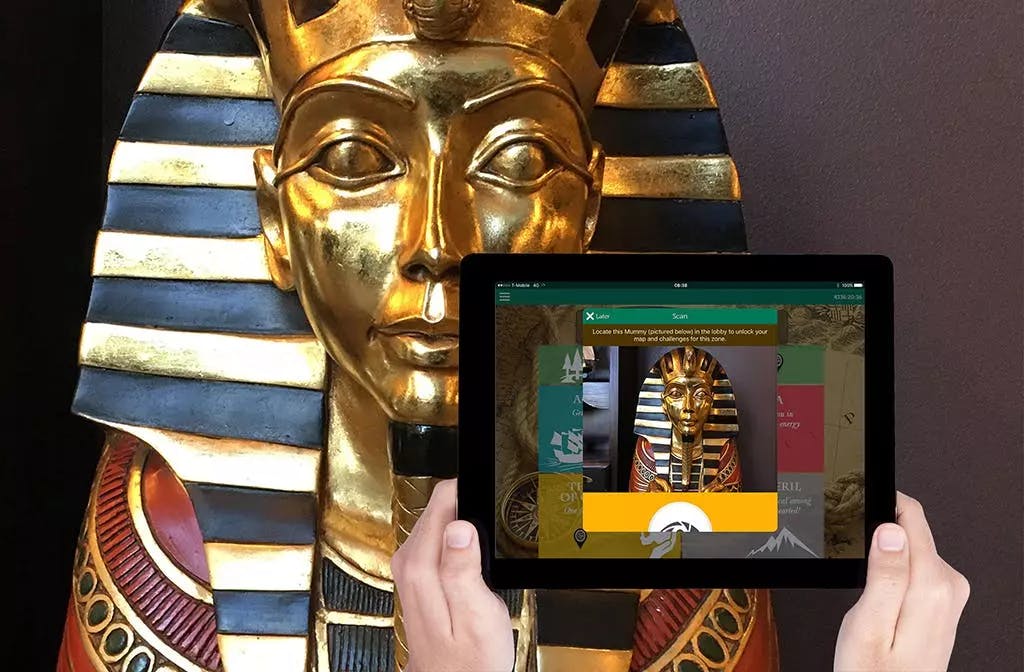 Holding a tablet up in front of an Egyptian mummy