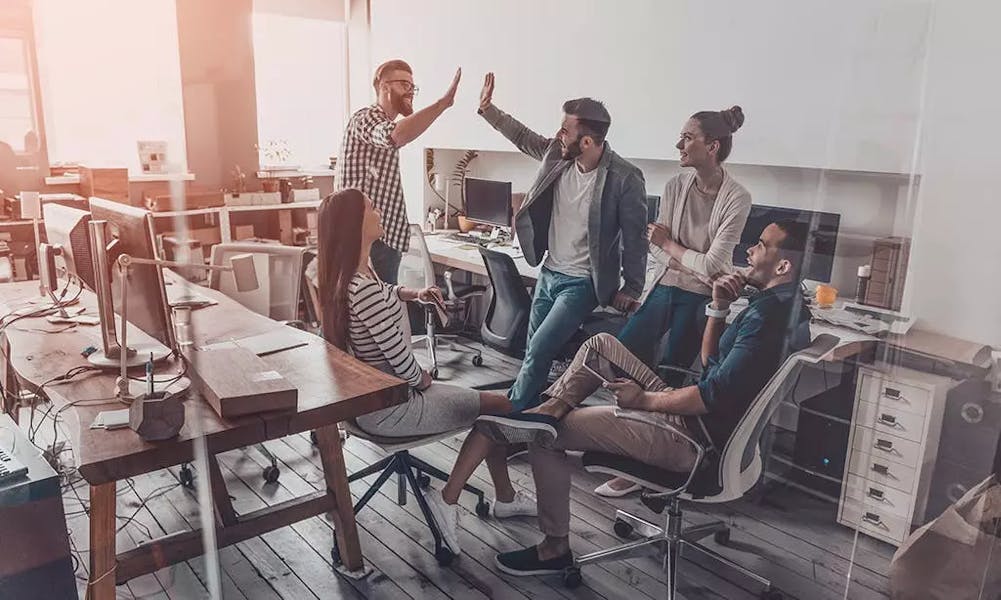 Happy colleagues give a high five in the office