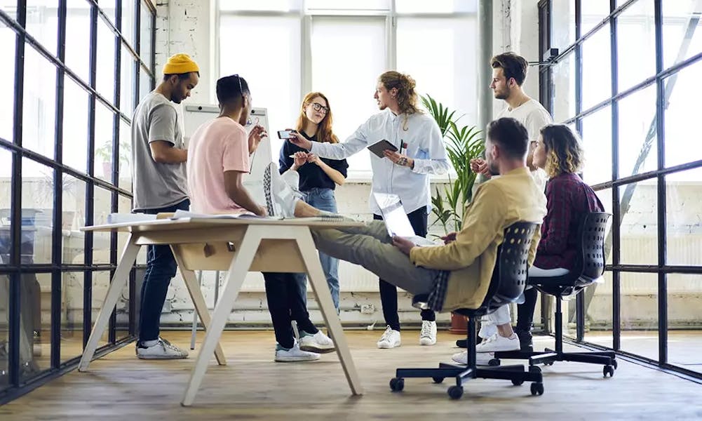 Modern office room with colleagues talking to each other