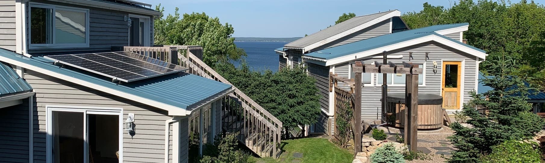 Two blue-roofed buildings on a hill overlooking the sea