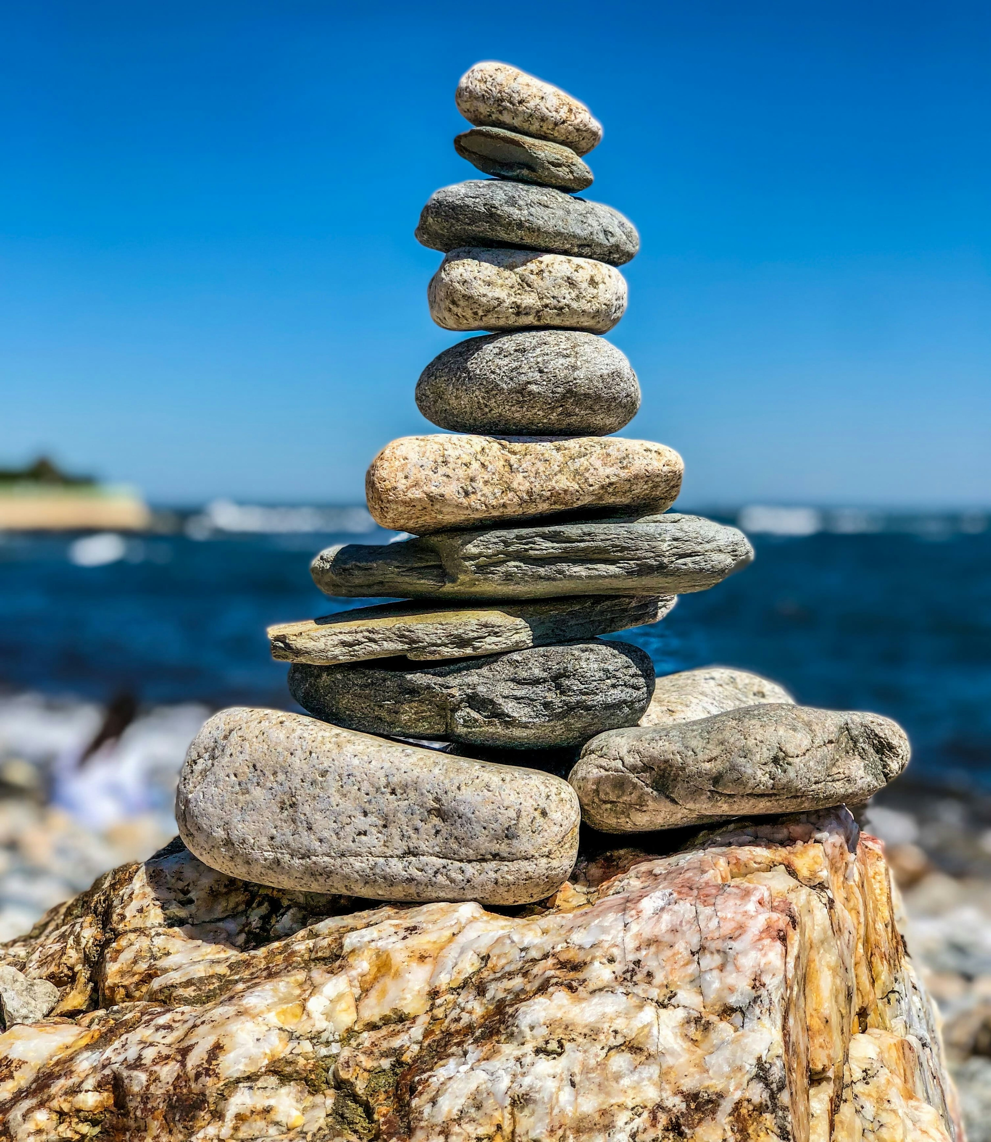 rocks stacked on boulder overlooking ocean